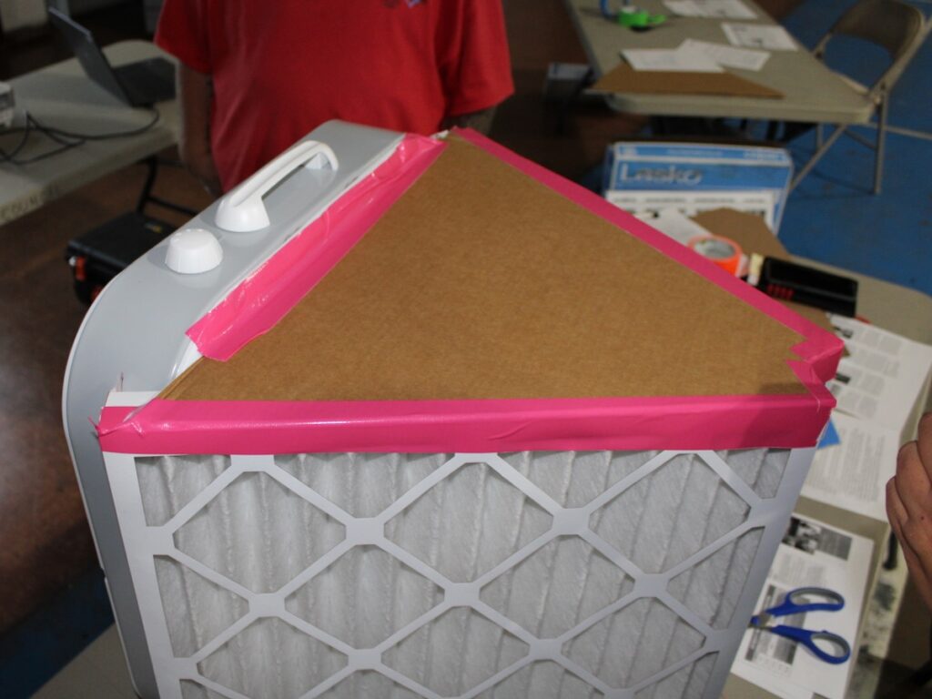air filtration system with a triangular piece of cardboard attached to top