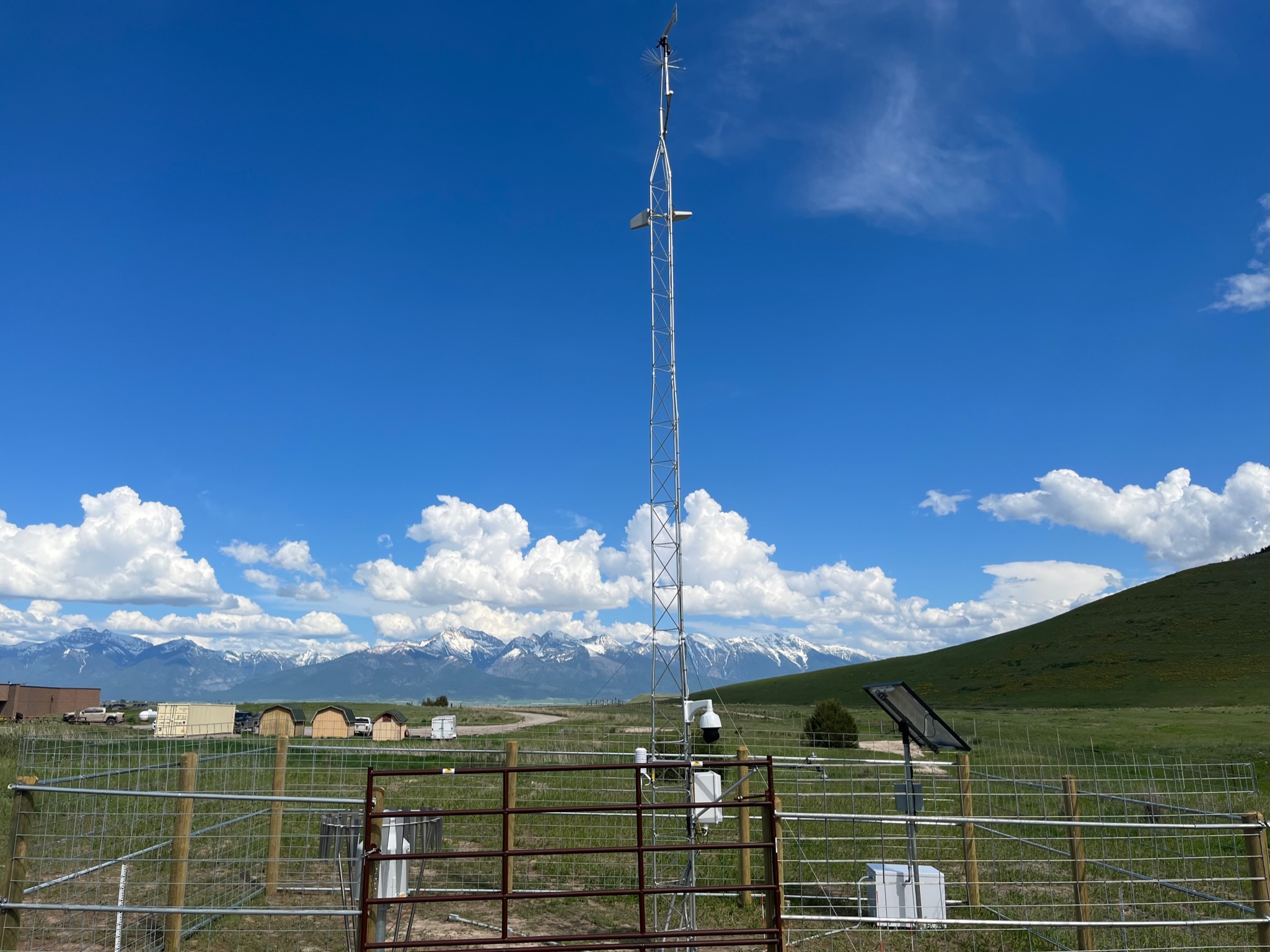 Tall metal pole against background of mountains and grassland