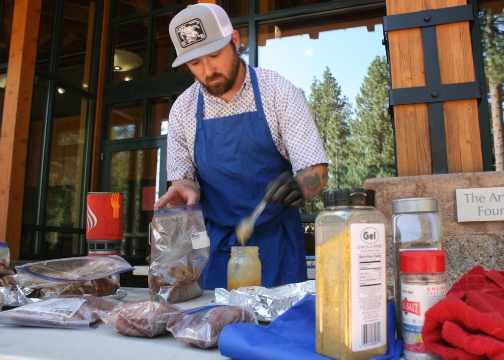 Austin Yohey of the University of Nevada Cooperative Extension marinates various types of fish and meat at the beginning of the potluck.