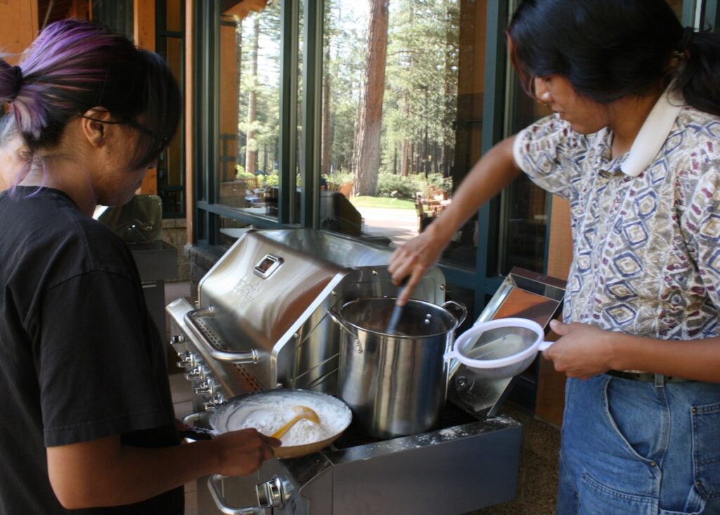 Tessa Smartt and Lance Owyhee of the Desert Farming Initiative cook a pot of chokecherry pudding at the Nevada Tribal Foods Summit