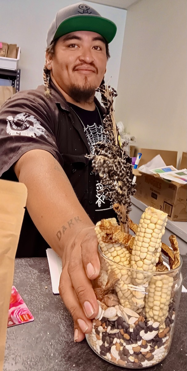 Juki Patricio holds a cup of dried corn